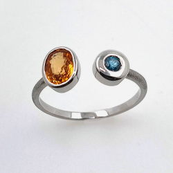 Ring aus 18KT Weißgold mit Granat, Spessartit und blauem Diamant.