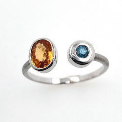 Anello in oro bianco 18KT con granato Spessartite e diamante blu.